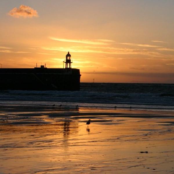 Sun setting behind lighthouse