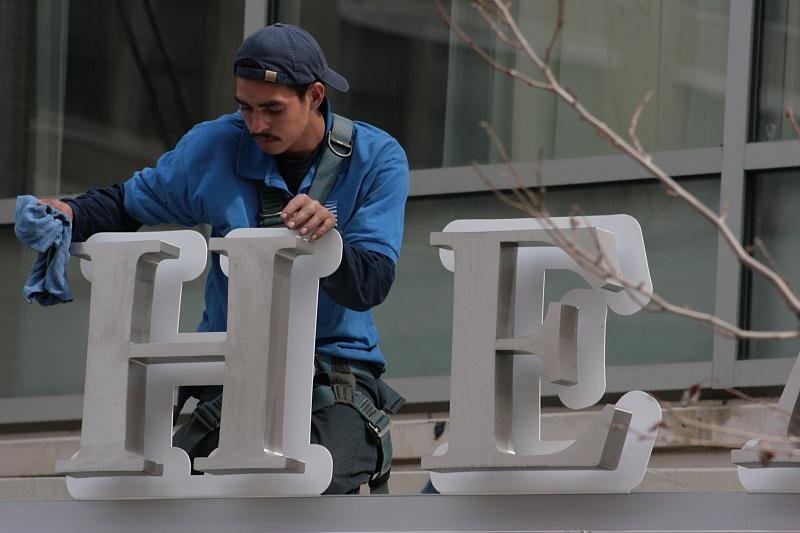 He is cleaning the sign