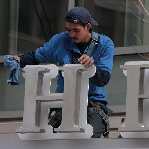He is cleaning the sign