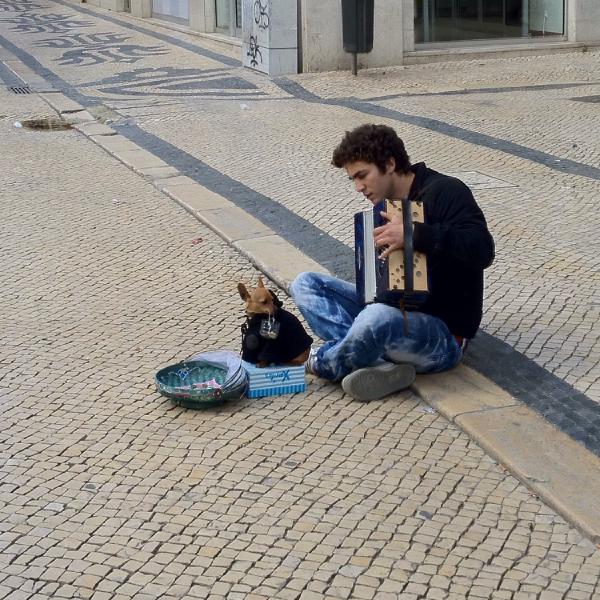 Busking with his dog with its basket
